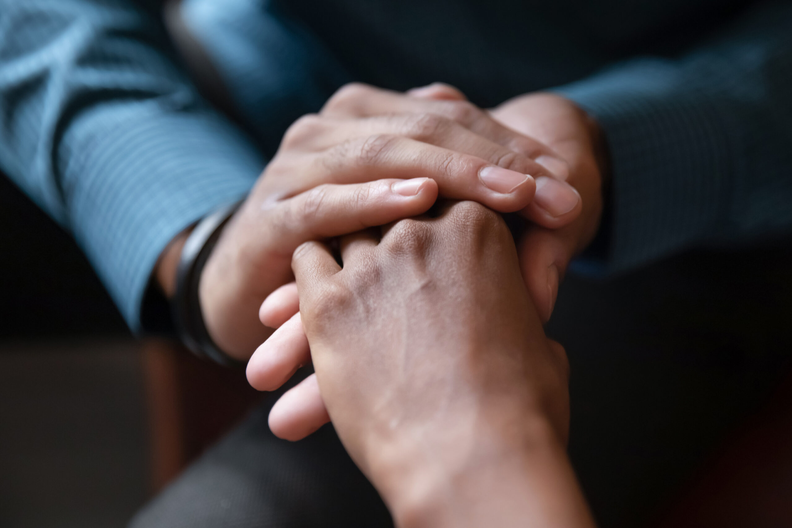 Hands clasped together, symbolizing support and connection, highlighting the importance of empathy and understanding in relationships.